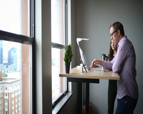 Person doing a light stretch near an office window